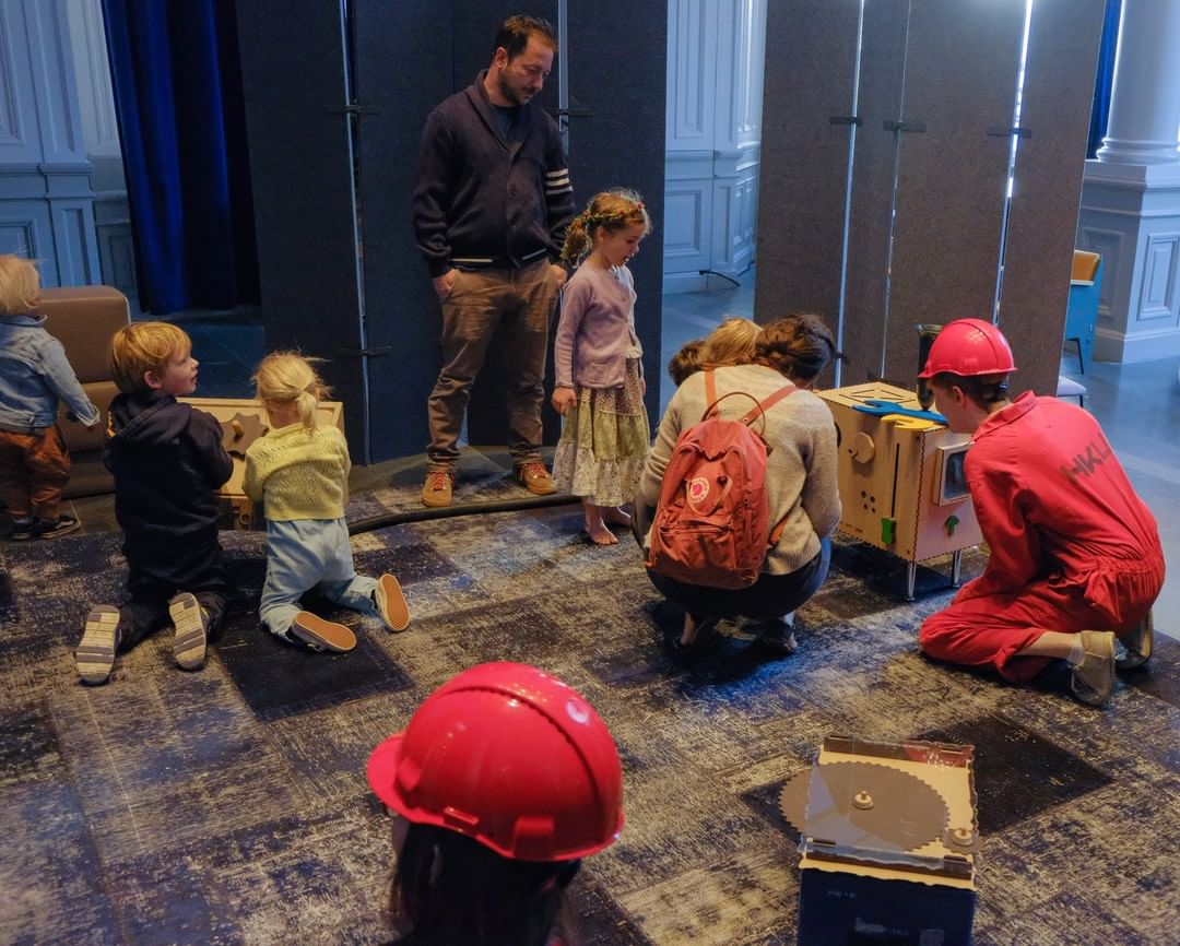 a photo of a festival room, a group of children is playing with the muziekfabriek
